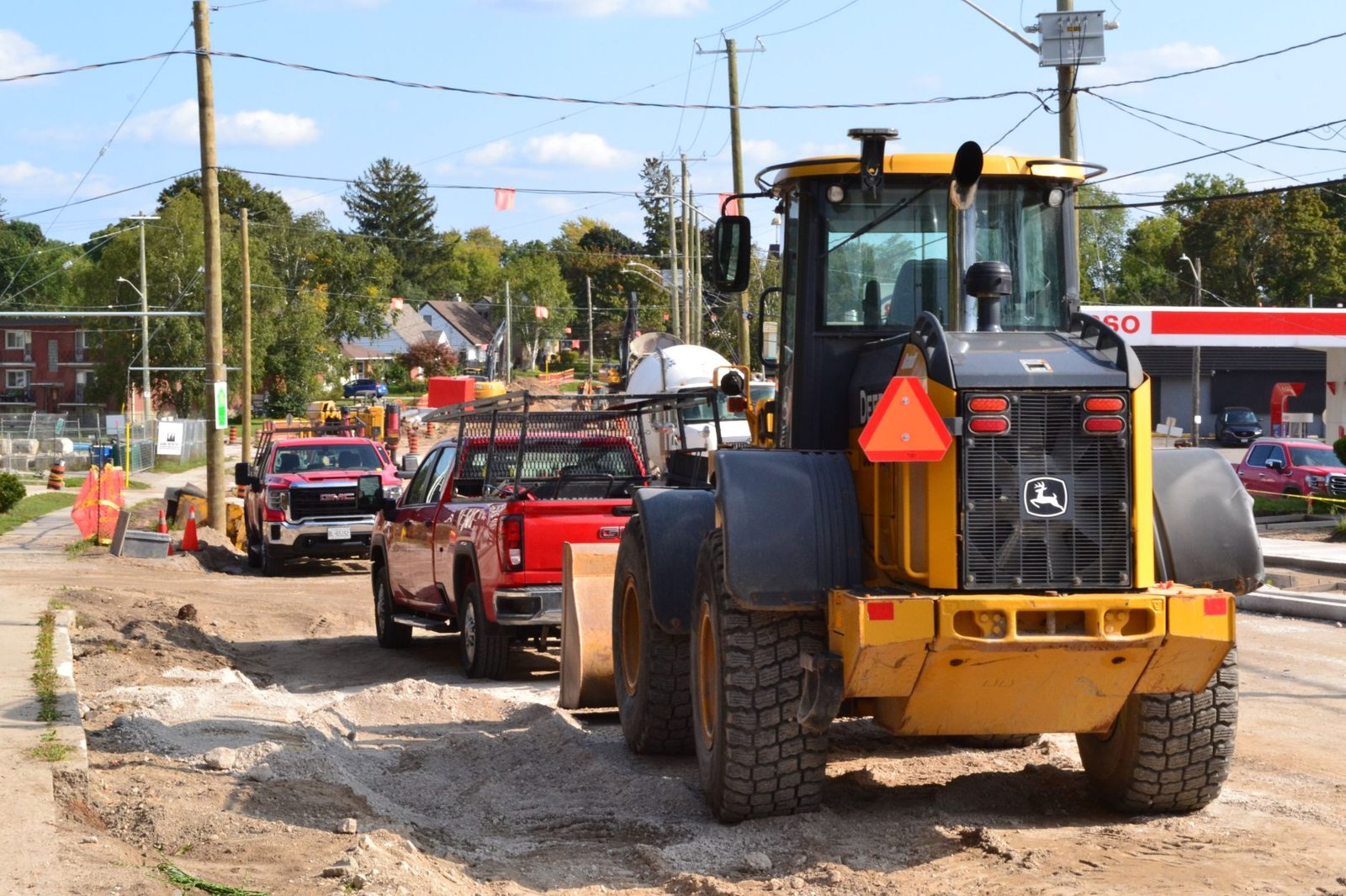 A loader and work trucks on a street project