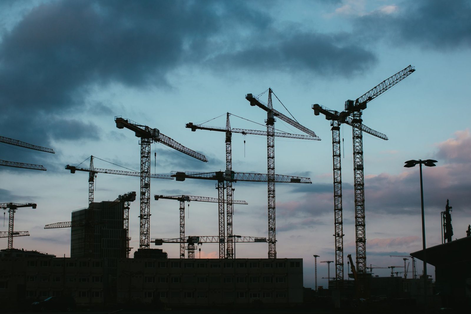 Tower cranes against an evening sky