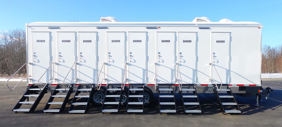 Row of eight individual shower stall doors with fold out steps along the private shower trailer