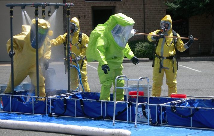 Response personnel processing contaminated gear, the kind of load camp laundry has to handle safely
