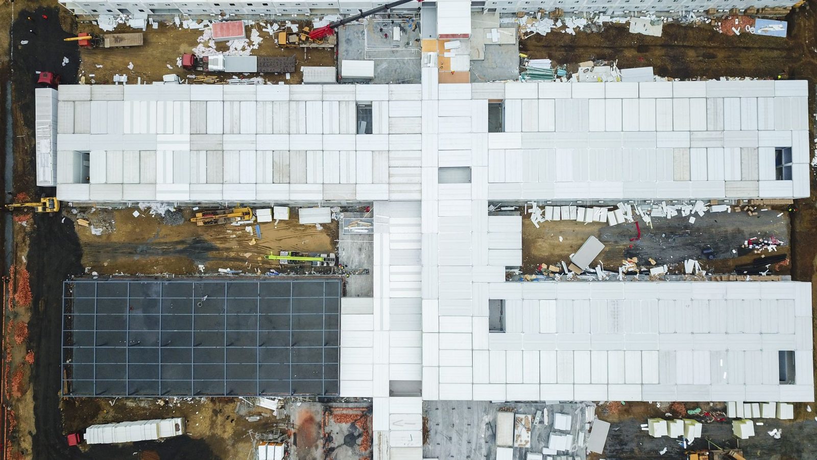 An aerial view of a large building site with staging areas