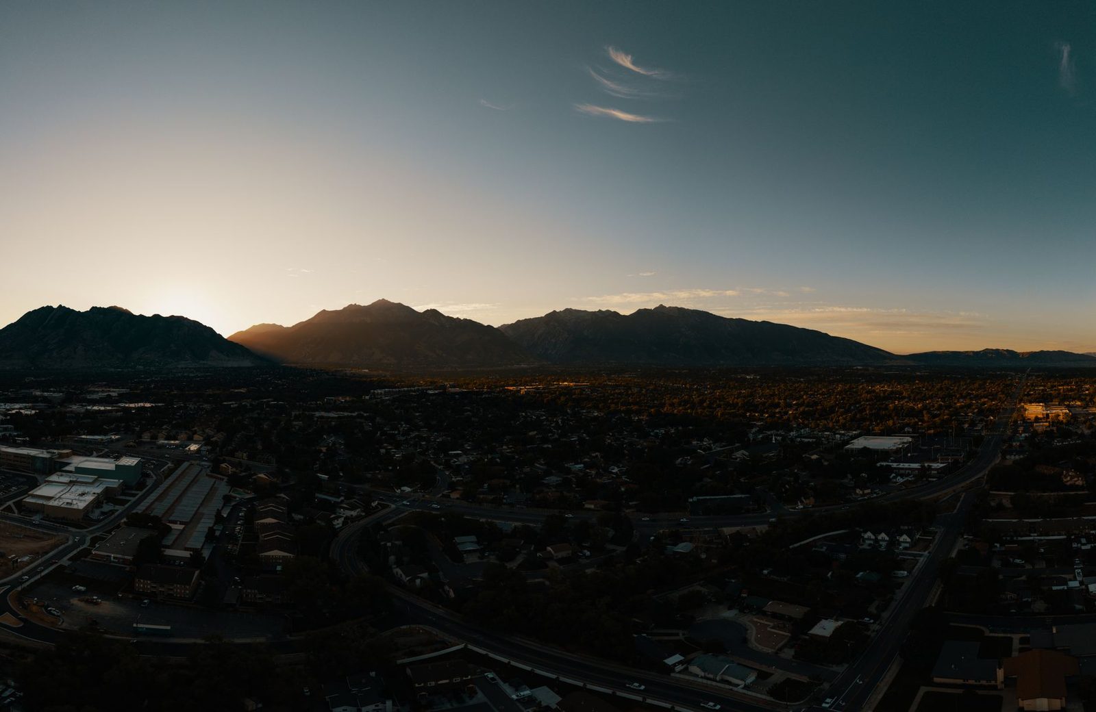 A valley city under a mountain range at sunrise