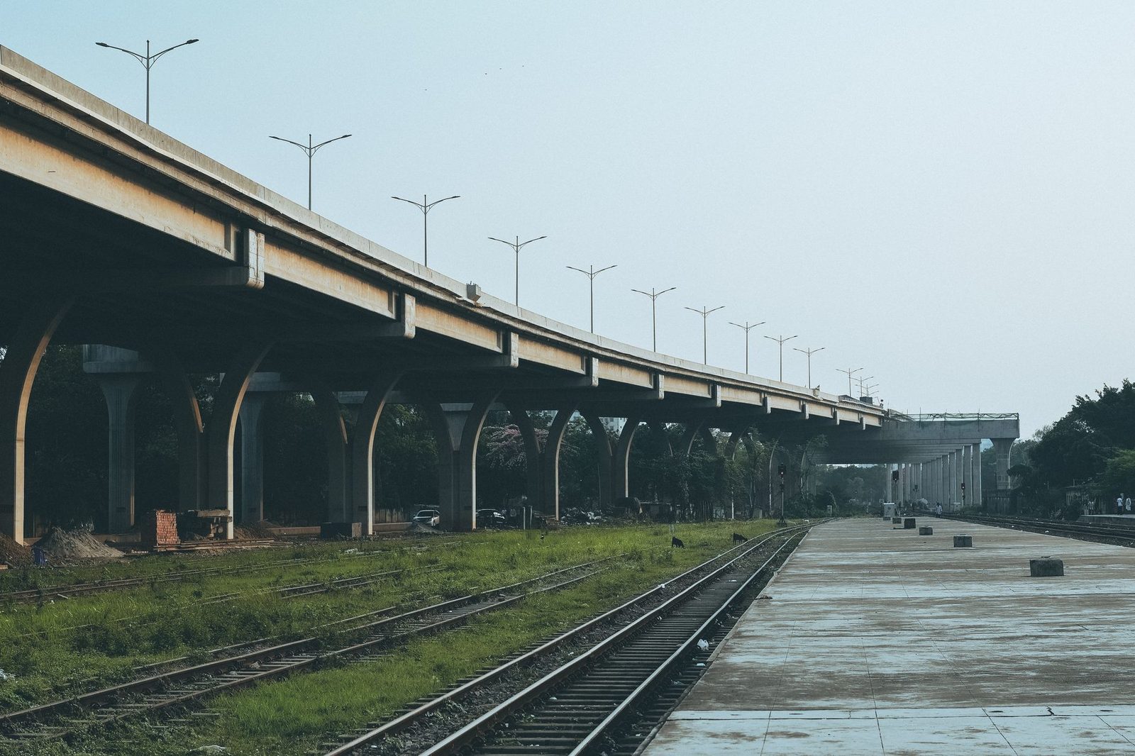 An elevated concrete viaduct running beside a rail line