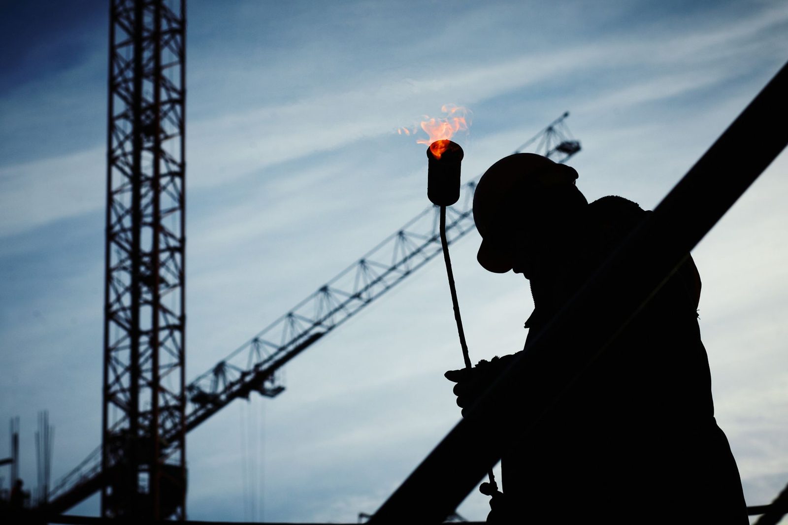 A worker silhouetted against the evening sun on a job site