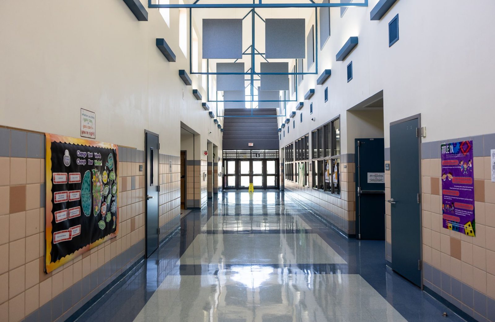 A clean school hallway with lockers and bulletin boards