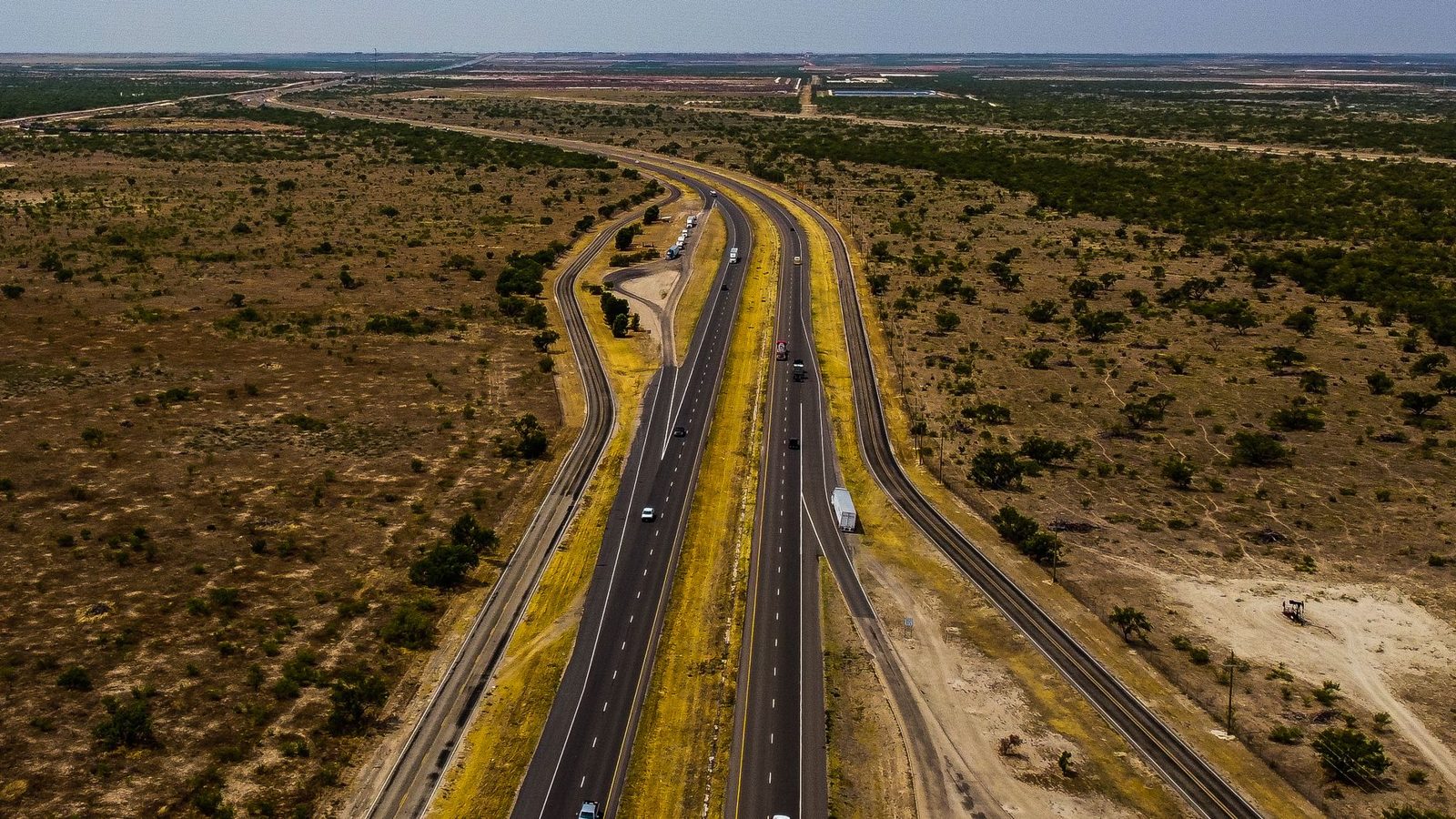 A highway crossing flat scrubland in West Texas