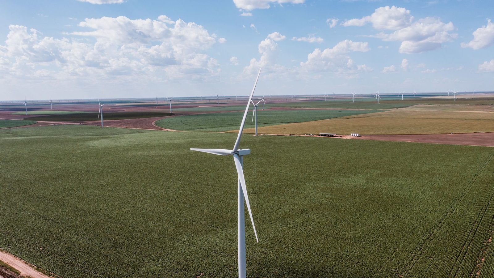 Wind turbines across green West Texas farmland