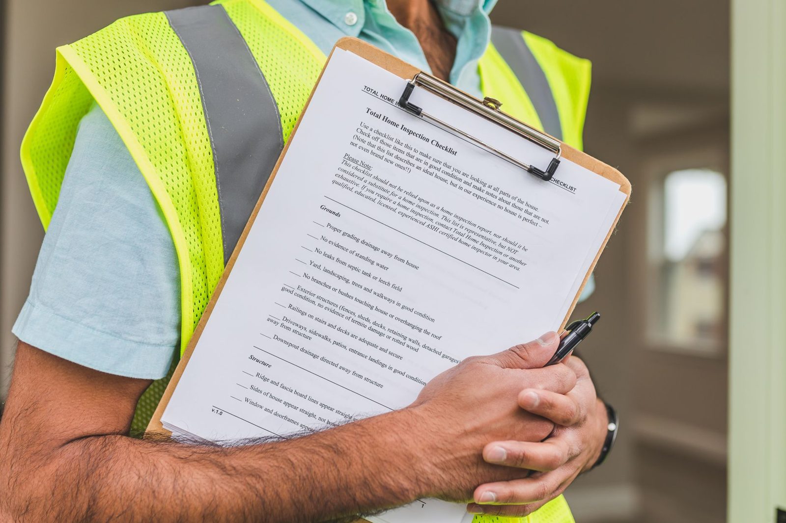A worker in a safety vest holding an inspection checklist