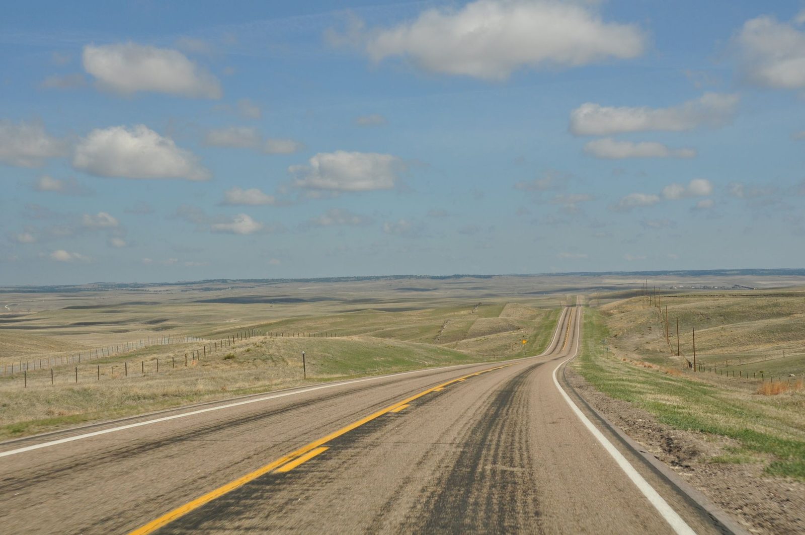 A two-lane highway running straight across the Colorado eastern plains