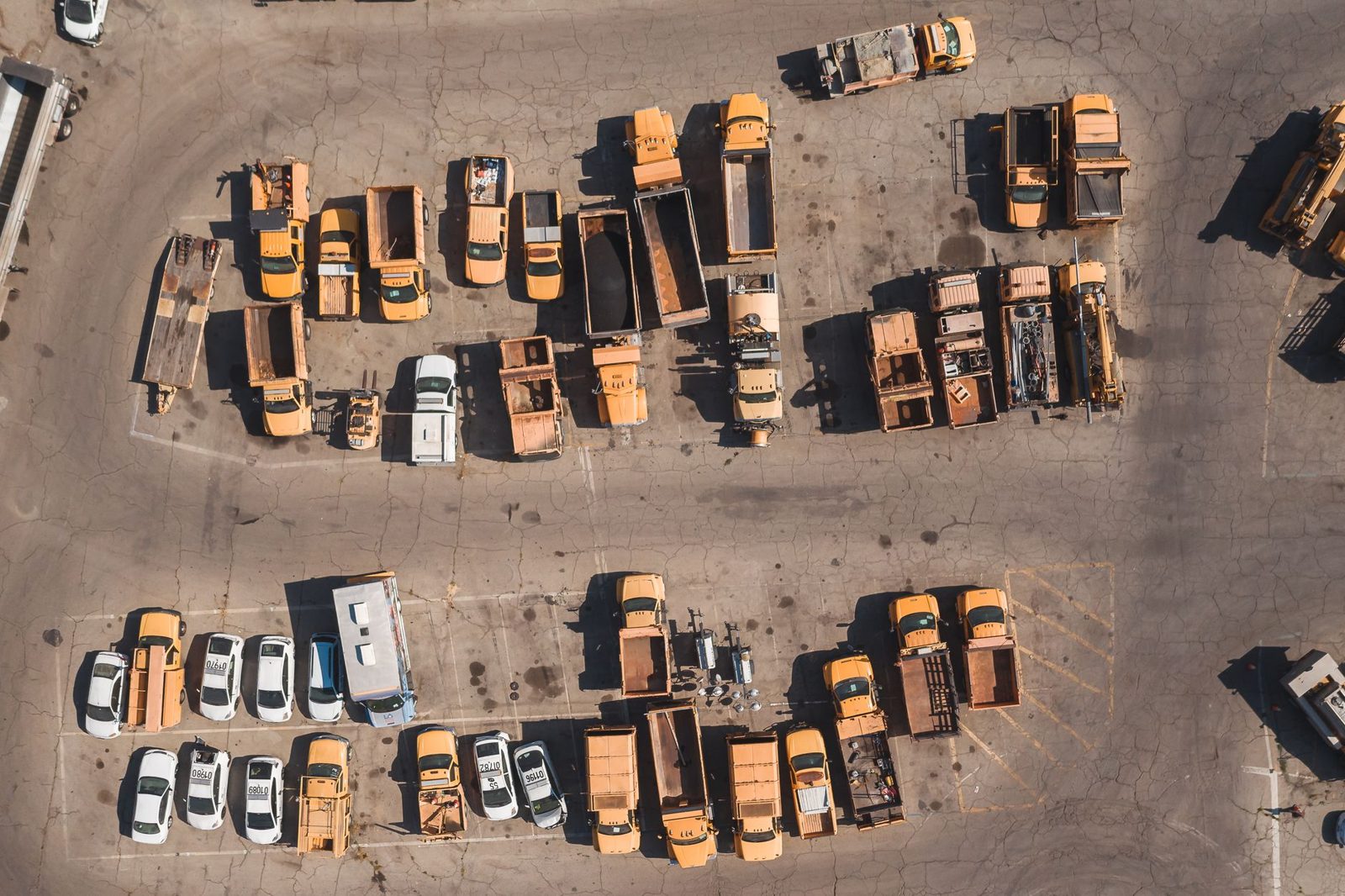 An aerial view of work trucks lined up in a staging lot