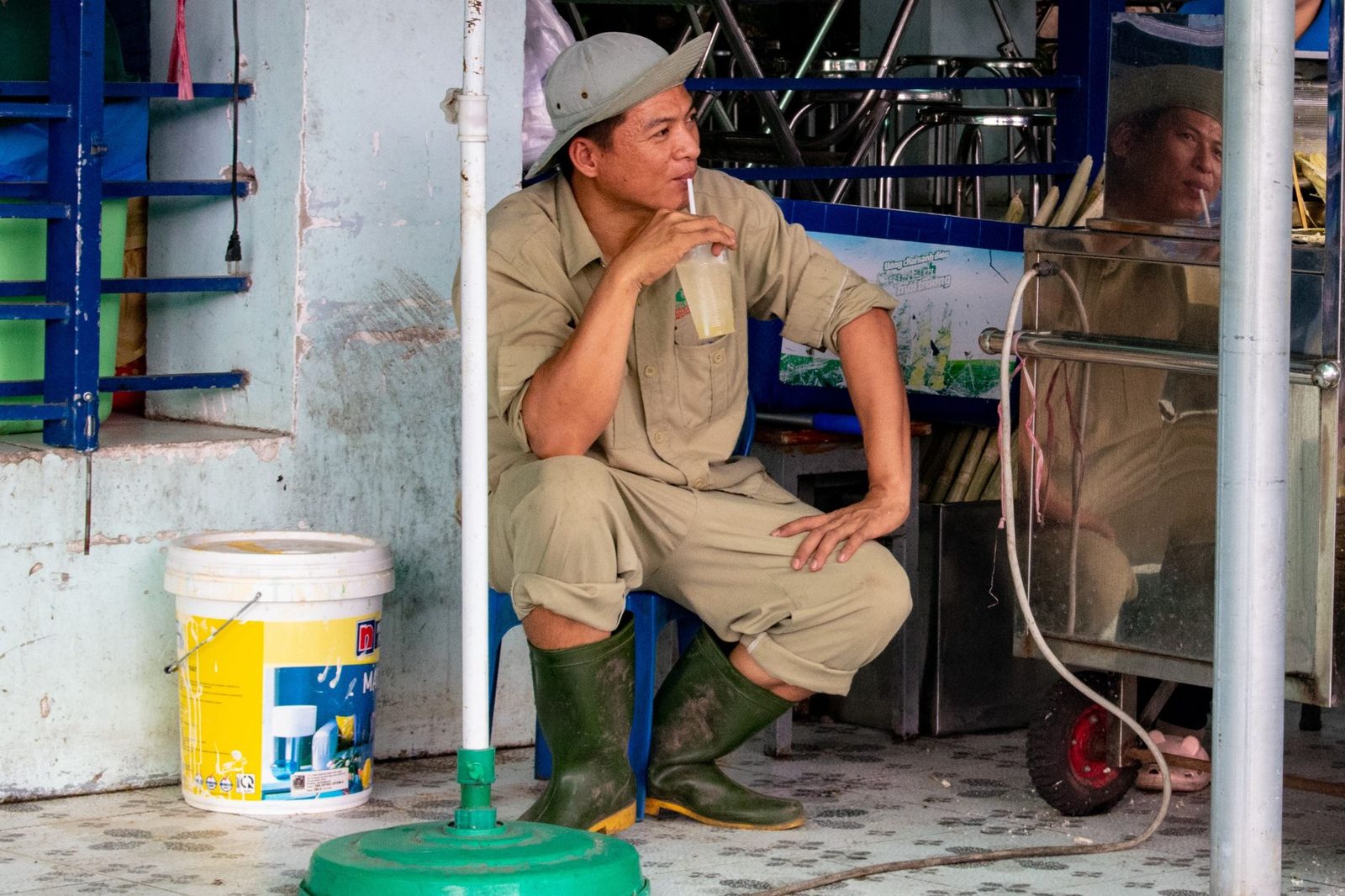 A worker taking a break in the shade of a shop