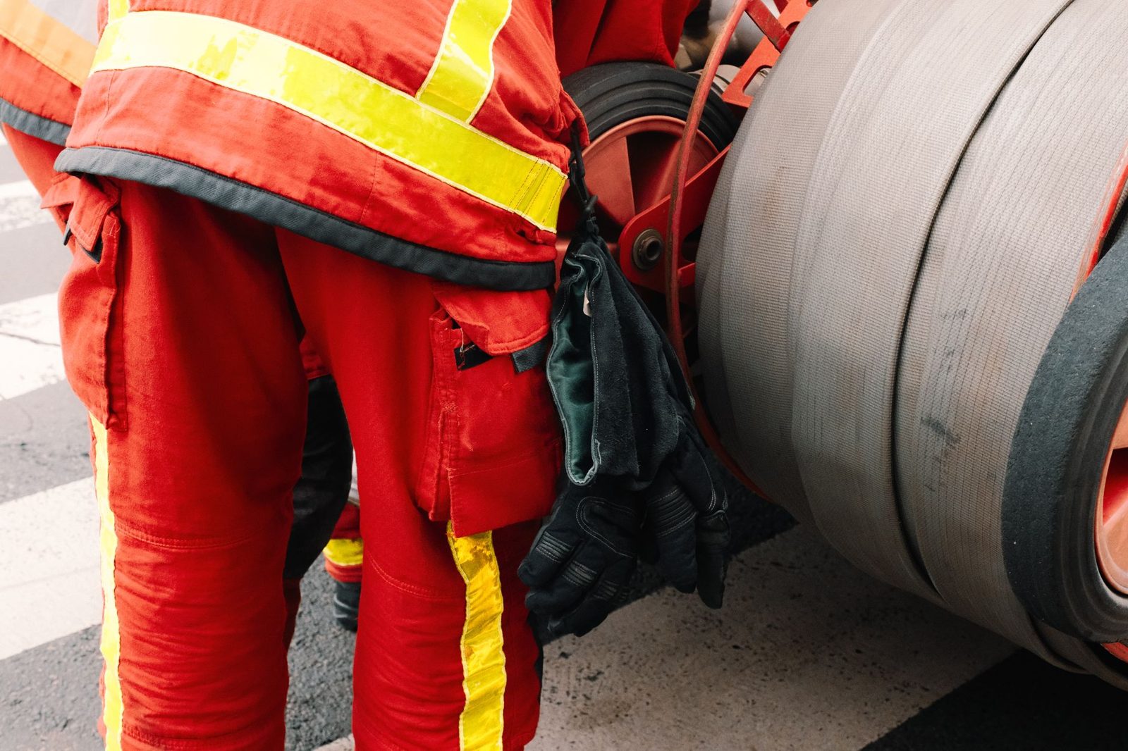 A firefighter handling hose gear after a shift