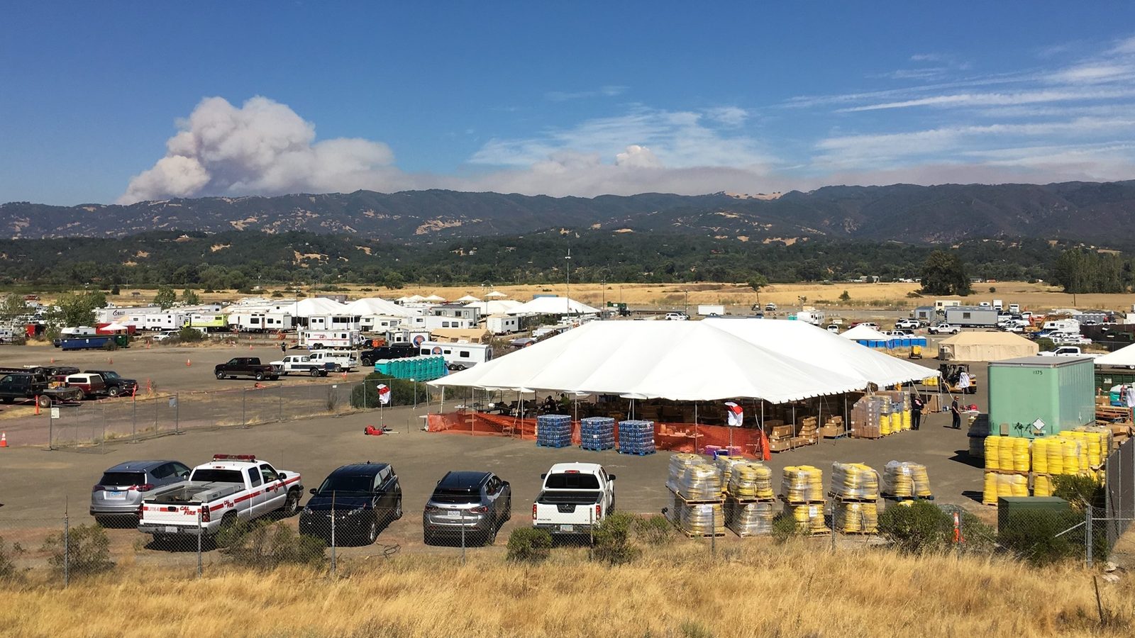Aerial view of an active wildfire response basecamp with staging and support areas